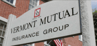 Sign for Vermont Mutual Insurance Group with logo and brick building in background.